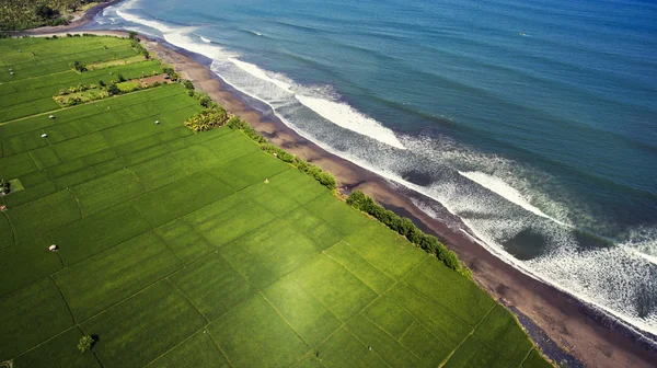 Foto aérea de vista superior desde el avión no tripulado volador de hermosa vista a la orilla del mar con playa de arena negra y buenas olas del océano para el surf . —  Fotos de Stock