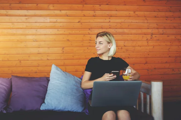 Hippi kız arıyor arkadaşlarına, süre ile cep telefonu ve dizüstü bilgisayar kafede oturuyor — Stok fotoğraf