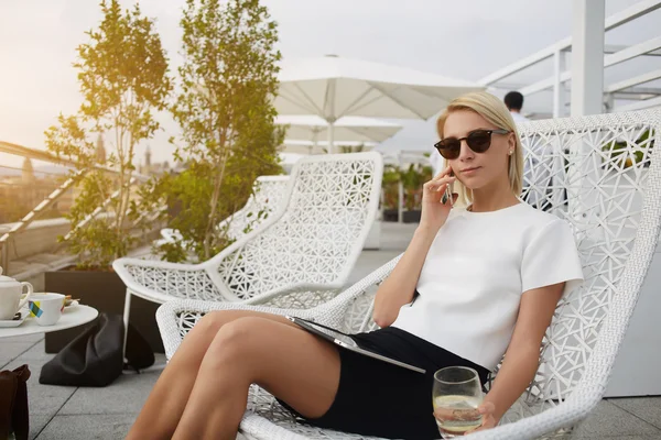 Moderne zakenvrouw is bellen via slimme telefoon om partner te worden wat ze verwachten in luxe restaurant in de frisse lucht. — Stockfoto