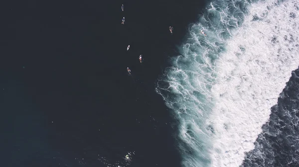 Vista dall'alto foto aerea dall'altitudine del gruppo di persone praticare sport acquatici di superficie nell'Oceano Indiano a Bali . — Foto Stock