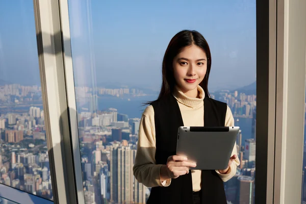 Jovem mulher asiática está segurando tablet digital portátil — Fotografia de Stock