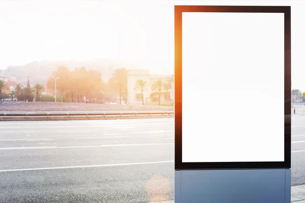 Tablero de información pública en la carretera de la ciudad, la luz del sol llamarada. Caja de luz vacía al margen de la configuración urbana — Foto de Stock