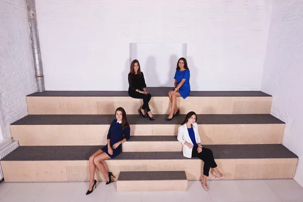 Молодые квалифицированные деловые женщины сидят вместе в современном офисном интерьере с современным дизайном . — стоковое фото