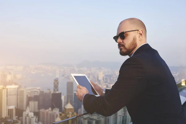 Jovem empresário via tablet moderno — Fotografia de Stock