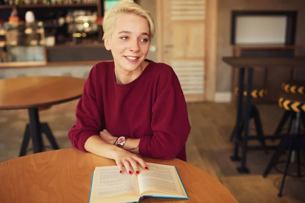 Hipster in goede stemming boek literatuur lezen terwijl het hebben van vrijetijd in de coffeeshop — Stockfoto
