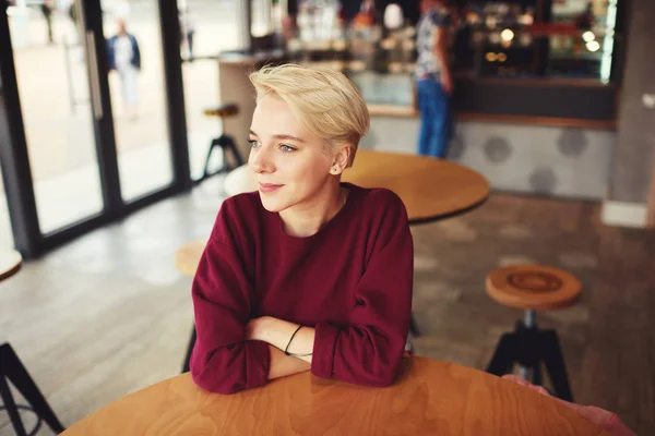 Hipster with trendy short haircut looking into the window feeling calm during recreational time while — Stock Photo, Image