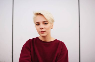 Doğal makyaj ve kısa saç kesimi ile dikkatli erkek şık Kazak giymiş 