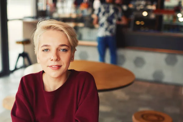 Hipster esperando a su compañero de clase en acogedora cafetería interior — Foto de Stock