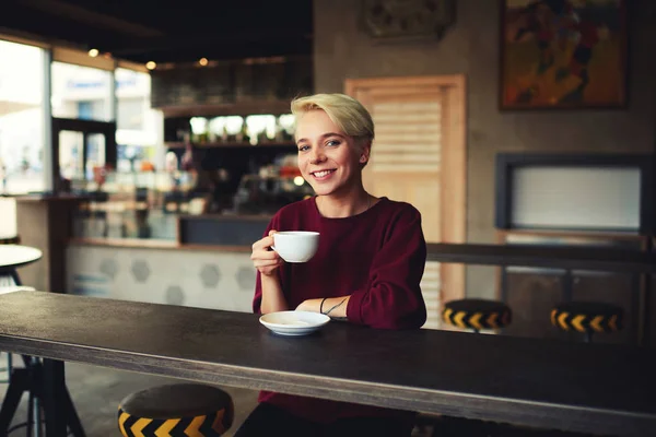 Hipster girl with short haircut drinking hot chocolate for breakfast in morning — Stock Photo, Image