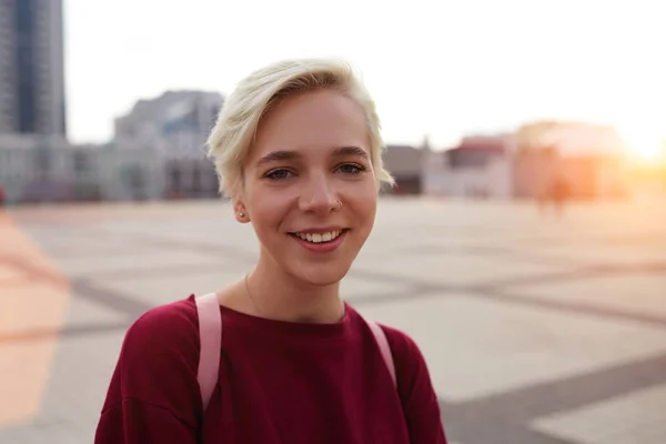 Estudiante hipster agradable pasar tiempo al aire libre caminando en la calle de la ciudad en el centro con mochila rosa —  Fotos de Stock