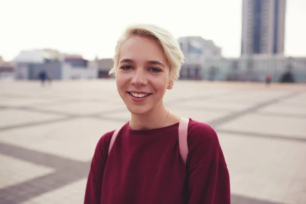 Étudiant hipster passant du temps dehors à marcher sur la rue de la ville au centre-ville avec sac à dos rose — Photo