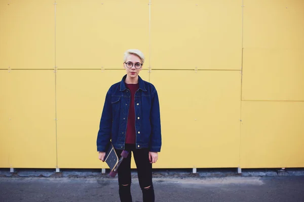 Hipster tendo tempo livre enquanto pratica com longboard na rua da cidade — Fotografia de Stock