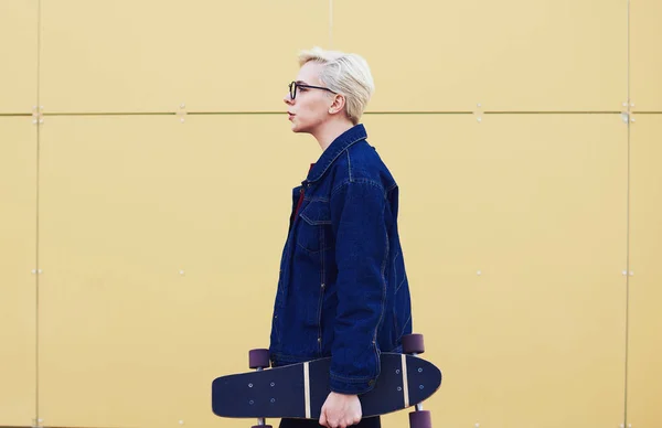 Sported girl  practicing in sports activities with skateboard standing near copy space for your advertising — Stock Photo, Image