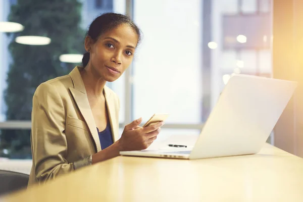 Denken meisje via smartphone en laptop met wifi in office coworking — Stockfoto