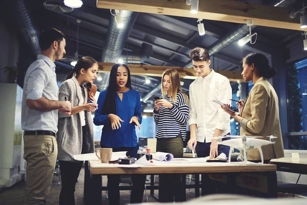 Estudiantes concentrados mediante aplicación en dispositivos digitales conectados a conexión inalámbrica a Internet en interiores o exteriores —  Fotos de Stock