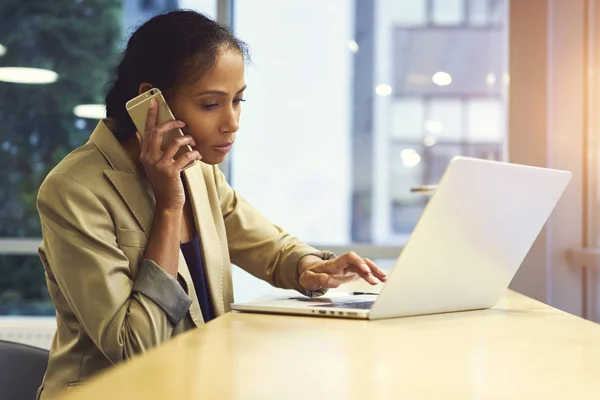 Alleenstaande vrouw via moderne laptopcomputer en draadloze verbinding met internet zitje in kopie kantoorruimte voor uw reclame — Stockfoto