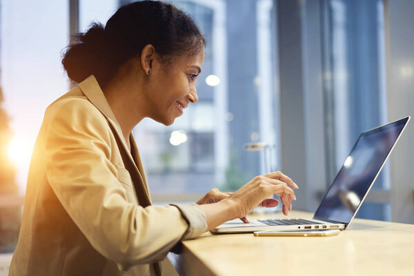 Attractive afro american woman accounting watching streaming video during work break 