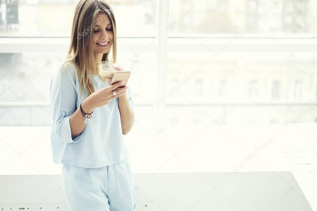 Coworker girl  via smartphone using wireless connection in coworking space