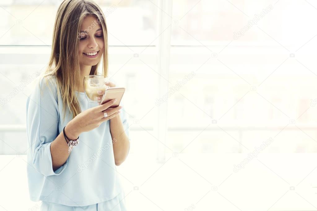 Likable girl using wifi connection standing on copy space for advertising