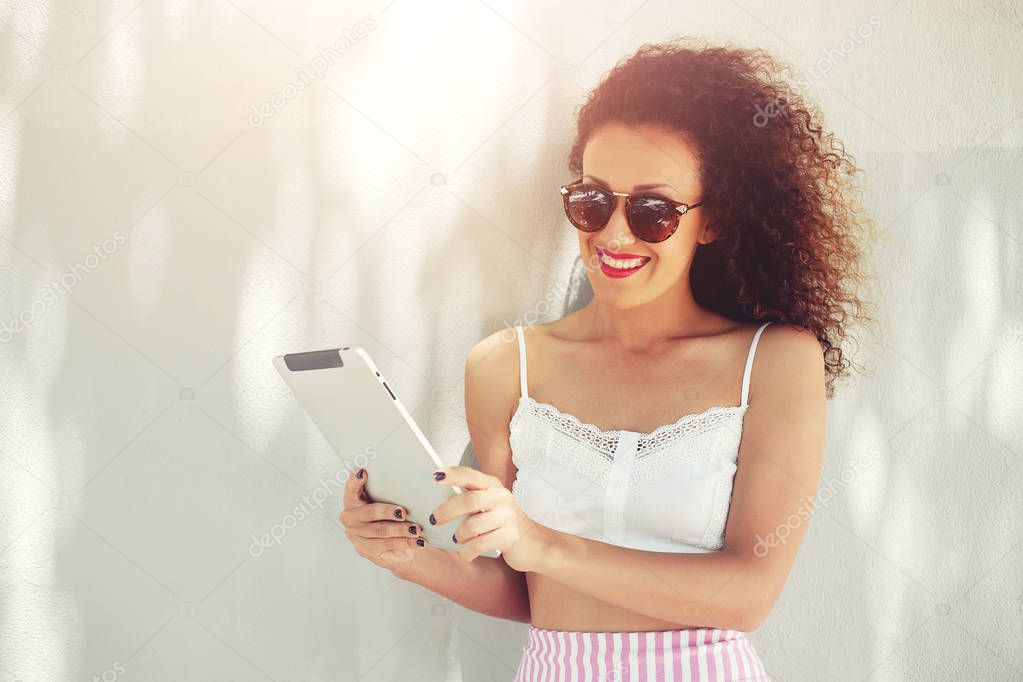 Smiling female holding digital tablet against copy space area for advertising content or text message