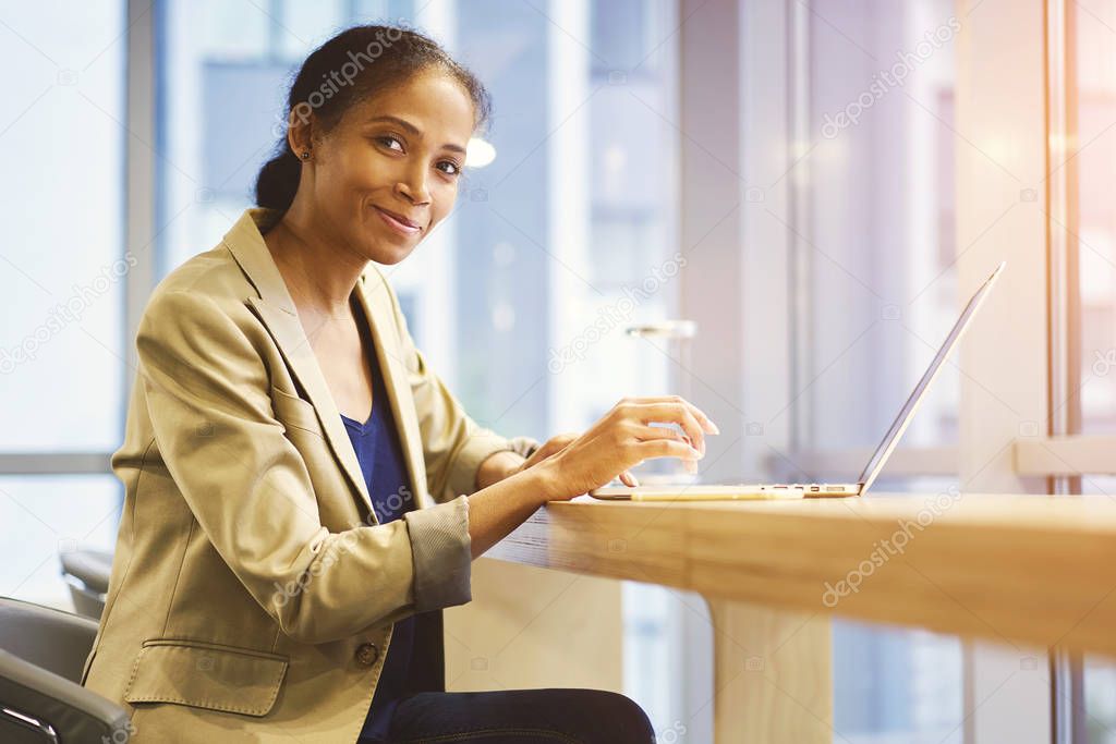 Nice hipster girl using wireless connection to internet in office copy space area for your advertising content