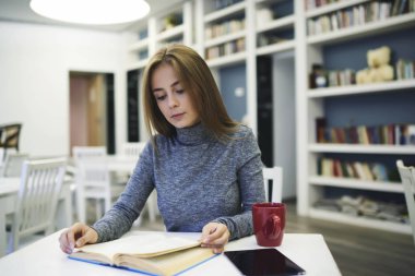 Çekici kız dersler başlamadan önce kahvaltı için sıcak kahve içme