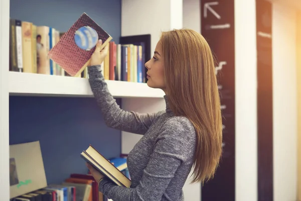 Munteres Mädchen arbeitet in modern gestalteter Universitätsbibliothek für Studenten und Schüler — Stockfoto
