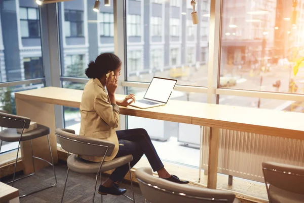 Ejecutivo afroamericano joven haciendo trabajo remoto estar en viaje de negocios sentado en la mesa en el espacio de coworking — Foto de Stock