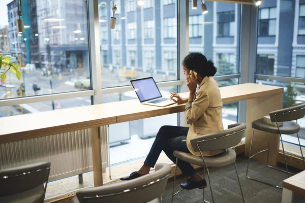 Ejecutivo afroamericano joven haciendo trabajo remoto estar en viaje de negocios sentado en la mesa en el espacio de coworking — Foto de Stock