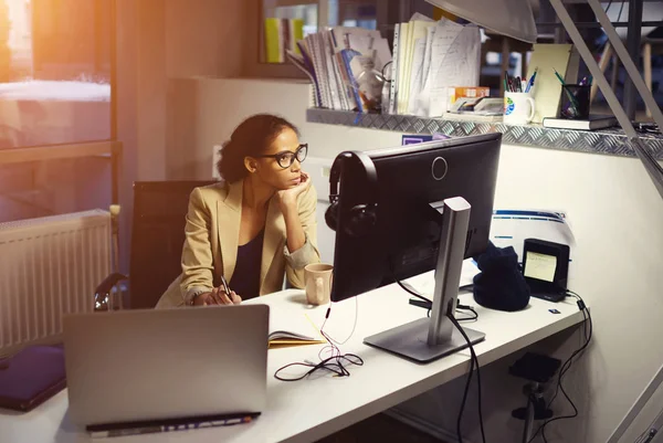 Unga kvinnliga yrkesjournalist arbetar hårt bor i office på kvällen — Stockfoto