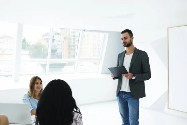 Yetenekli erkek bu yapım tanıtımı yeni yazılımın avantajları ve kullanılabilirlik hakkında konuşan programcı — Stok fotoğraf