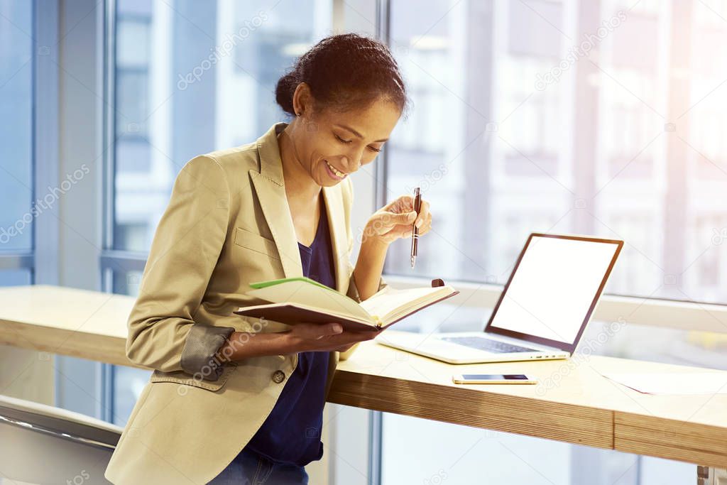 Hipster girl using technology and wireless connection standing in office copy space area for advertising