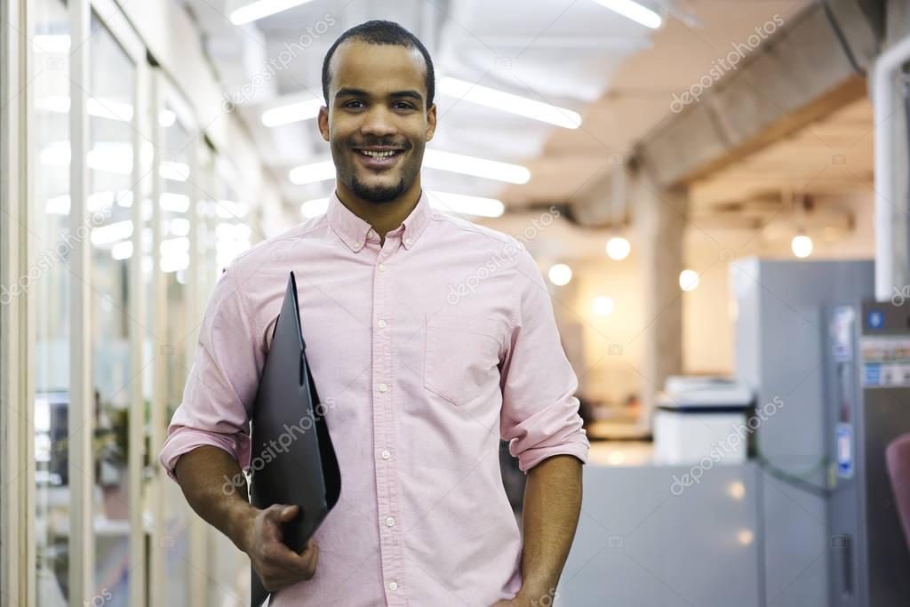 Smiling man preparing documents and financial reports for showing executive on morning meeting 