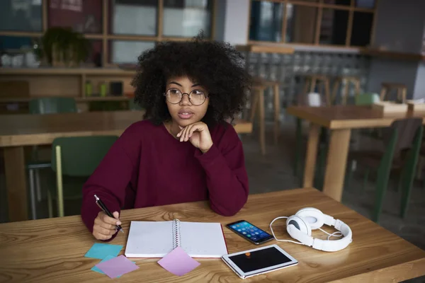 Amerikaanse vrouwelijke student huiswerk maken — Stockfoto