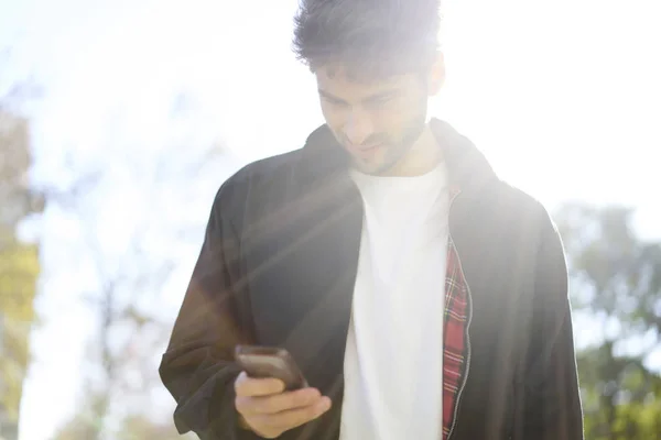 Caucasian hipster messaging outdoors — Stock Photo, Image