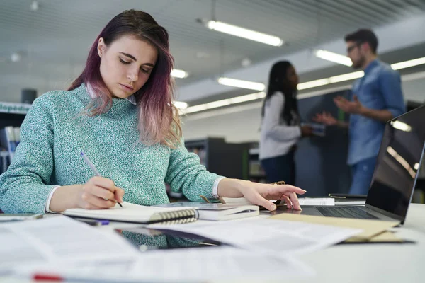 Estudante do sexo feminino escrita curso — Fotografia de Stock