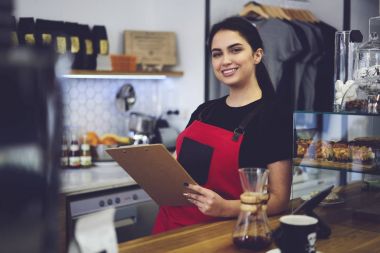 Servis ve satış yıllık gelirleri sayan gülümseyen İdari İşler Müdürü