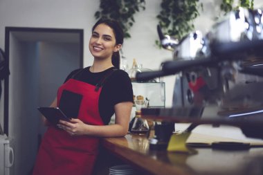 Kadın barista kahve tutan kameraya gülümseyen portresi
