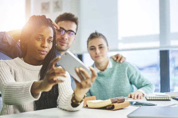 Grupo de colegas sorridentes, masculinos e femininos descansando durante a pausa para o trabalho, tirando selfie para as redes sociais — Fotografia de Stock