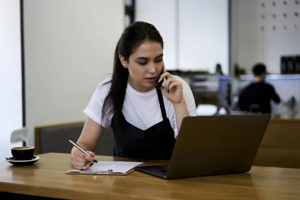 Vrouwelijke coffee shop eigenaar bellen voor de levering van de bestelling van het product — Stockfoto