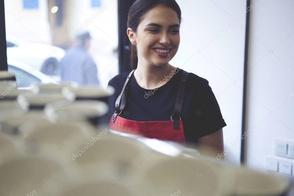Woman server with smile standing in cafe interior
