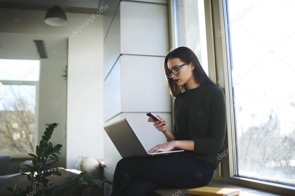 Beautiful hipster girl using laptop and 4G wireless internet connection for blogging