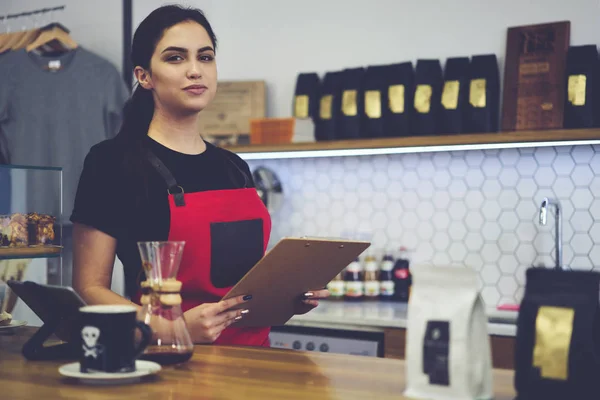 Hermosa camarera que tiene día de trabajo en la cafetería utilizando el dispositivo de almohadilla táctil digital — Foto de Stock