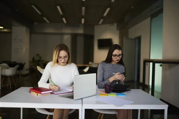 Smart students preparing for exams sitting in university library — Stock Photo, Image