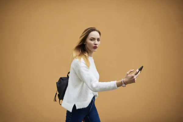 Hippi kız modern cep telefonu ile renkli arka plan üzerinde ayakta — Stok fotoğraf
