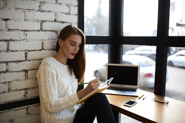 Creatieve vrouwelijke schrijver verbazingwekkende gedichten schrijven in eigen dagboek zitten in de ruimte tijdens pauze coworking — Stockfoto