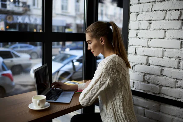 Jonge vrouwelijke verbinden met draadloze en genieten van koffie tijdens recreatie — Stockfoto