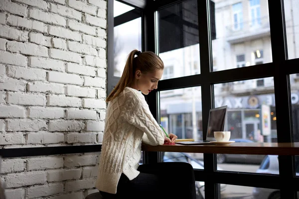 Jonge modeontwerpster maken nieuwe schetsen van nieuwe mode collectie werken van externe — Stockfoto