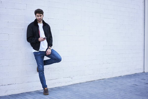 Hipster guy  chatting with friends in social network on mobile phone.