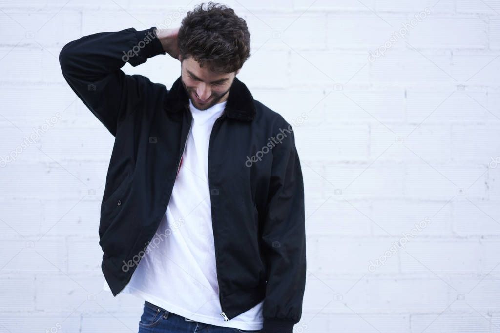 Young caucasian man dressed in casual clothing posing on street for fashion magazine collection